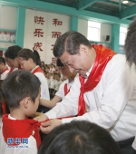 2014年5月30日，在北京市海淀区民族小学的少先队入队仪式上，习近平为新少先队员系上红领巾。新华社记者鞠鹏摄 - 广播电视