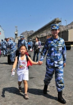2015年3月，也门，海军女战士牵着一名小女孩的手准备登上军舰。 - 广播电视